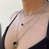 Collier acier trois rangs avec boules résine noire pendentif rond noir étoile et pompom